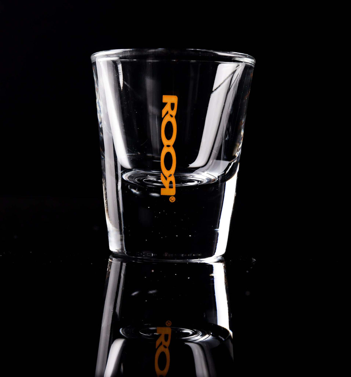 ROOR Shot Glass with thick clear base and orange decal.