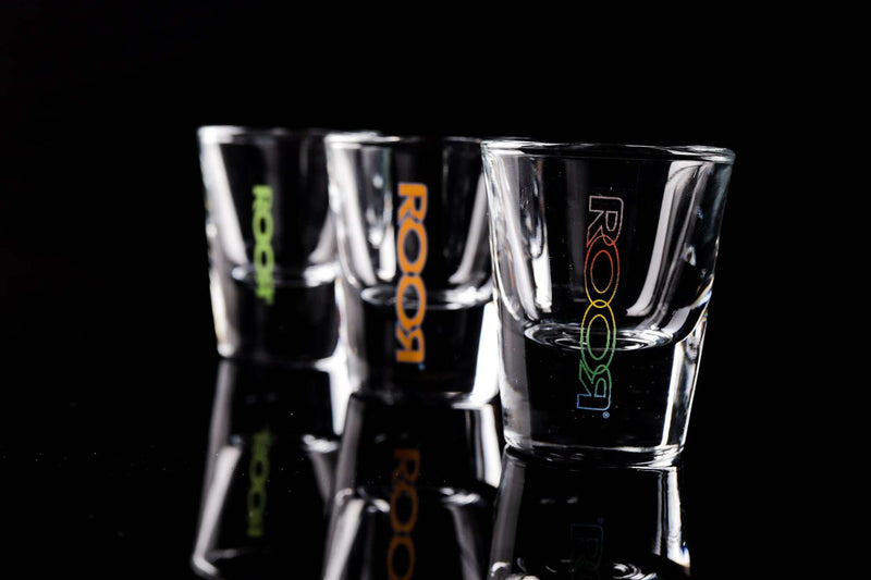 ROOR Shot Glass with thick clear base and assorted decals on black background.